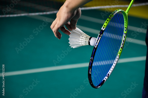Badminton serving by player in indoor badminton court, soft and selective focus on string and shuttlecock. © Sophon_Nawit