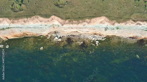 Top view of rocky cliff and calm sea