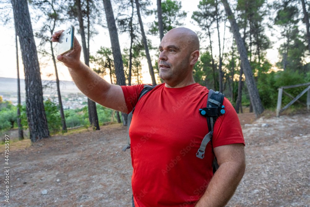 Caucasian and stocky hiker man, taking a picture with the mobile phone. Caucasian and stocky hiker man, taking a picture with the mobile phone.