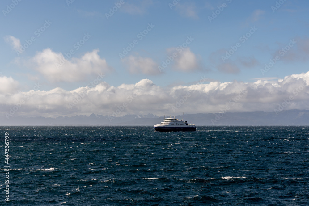 open ocean with whitecaps and a passenger ferry with the Lofoten Islands of Norway in the background open ocean with whitecaps and a passenger ferry with the Lofoten Islands of Norway in the background