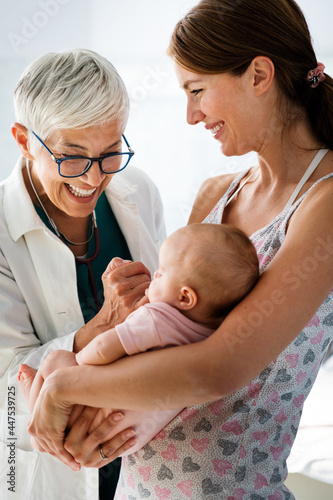 Canvas Print Mother holding baby for pediatrician doctor to examine