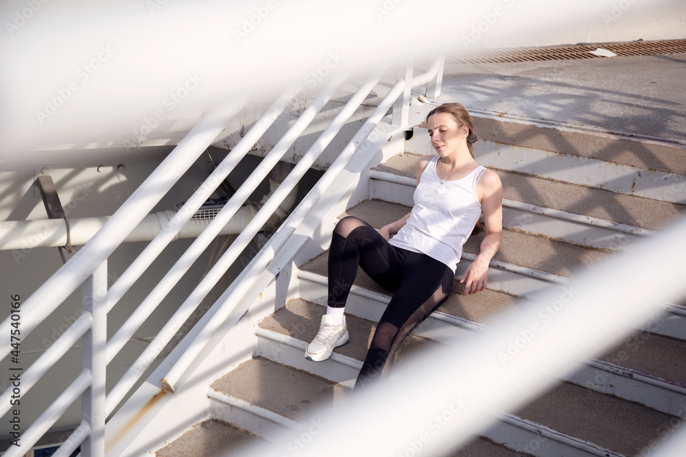 View of a woman sitting on the steps after a workout