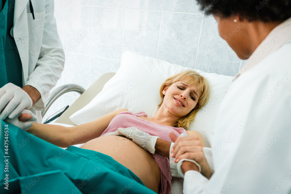 Obraz premium Woman giving birth in hospital with medical doctor team