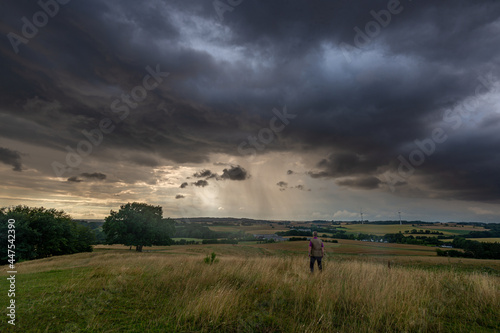 Dark sky and dramatic black cloud before rainy, man in the foreground