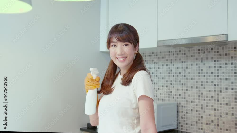 Young beautiful woman wearing protective rubber gloves is cleaning table in kitchen at home. Young beautiful woman wearing protective rubber gloves is cleaning table in kitchen at home.