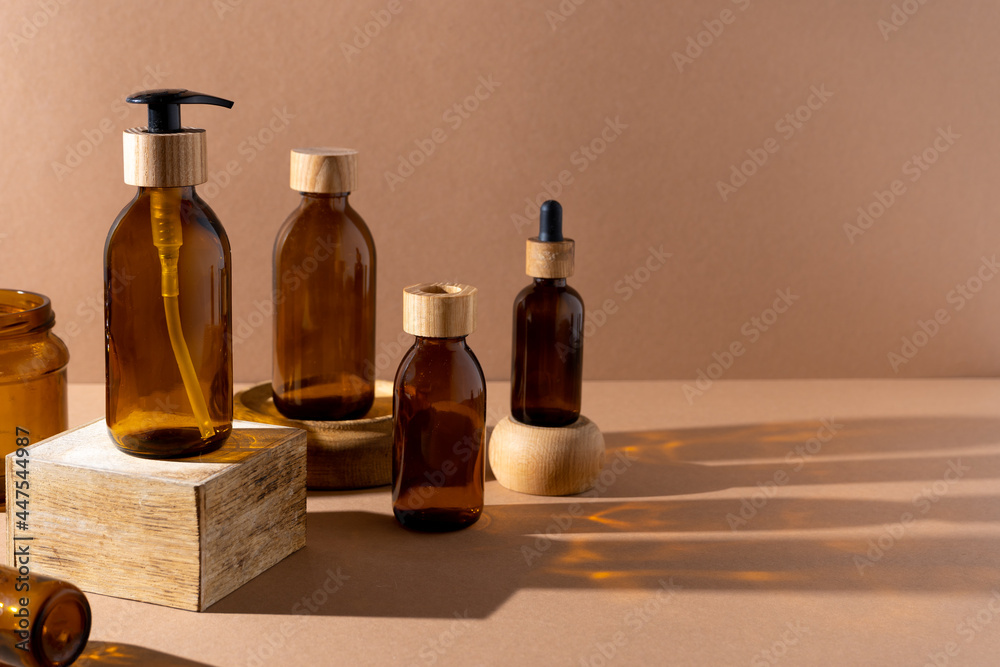 Eco friendly bottles for cosmetics. Glass bottle with a wooden lid with a dispenser and a pipette. Beauty and skin care. Brand packaging, place for text. Bottle products. Minimalism concept.