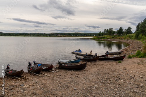 Fototapeta Naklejka Na Ścianę i Meble -  many wooden motorboats used for salmon fishing on the banks of the Tornionjoki River in Finnish Lapland