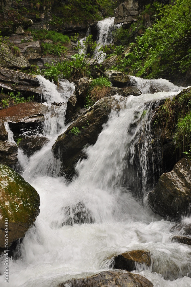 Mountain waterfall flowing through the forest. Mountain waterfall flowing through the forest.
