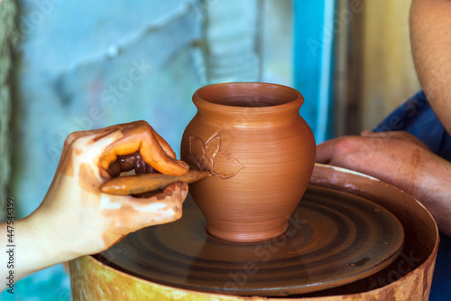Potter makes on the pottery wheel clay pot. Hand of the master close-up during work. Ancient national craft © Виталий Борковский