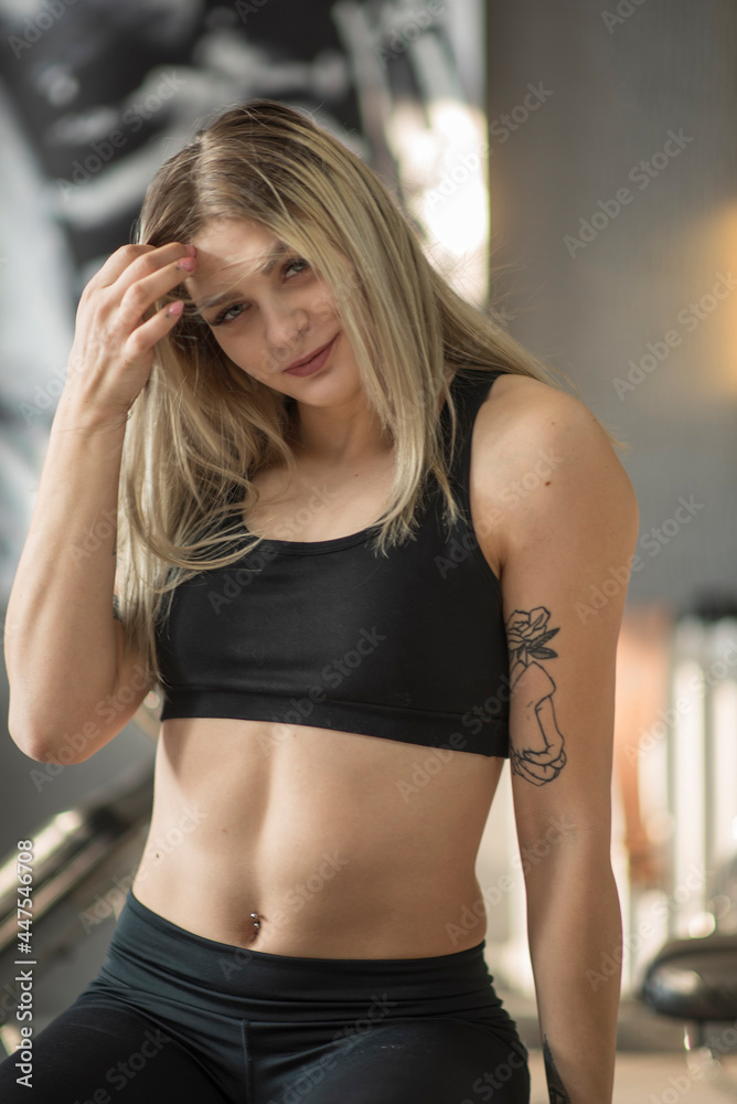 Young beautiful blonde girl posing in the gym. Young beautiful blonde girl posing in the gym.