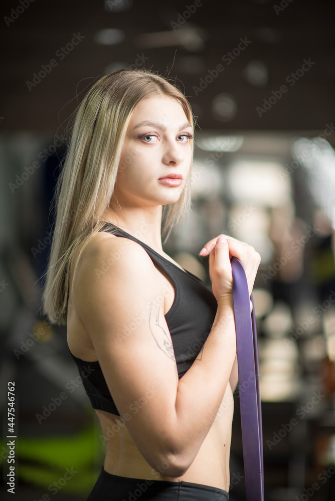 Young beautiful blonde girl posing in the gym.