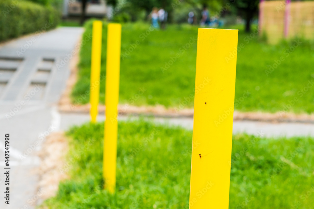 yellow poles by the sidewalk