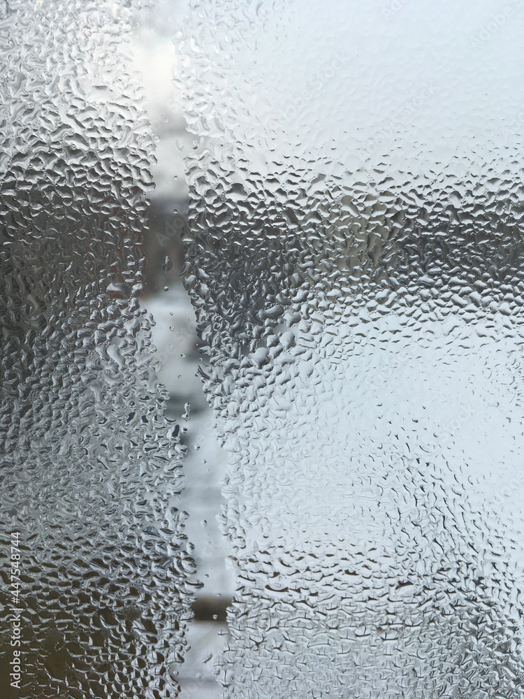 view from the window wet glass covered with wet flowing water, snow melts view from the window wet glass covered with wet flowing water, snow melts