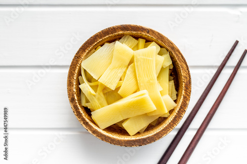 Sliced canned bamboo shoots in wooden bowl.