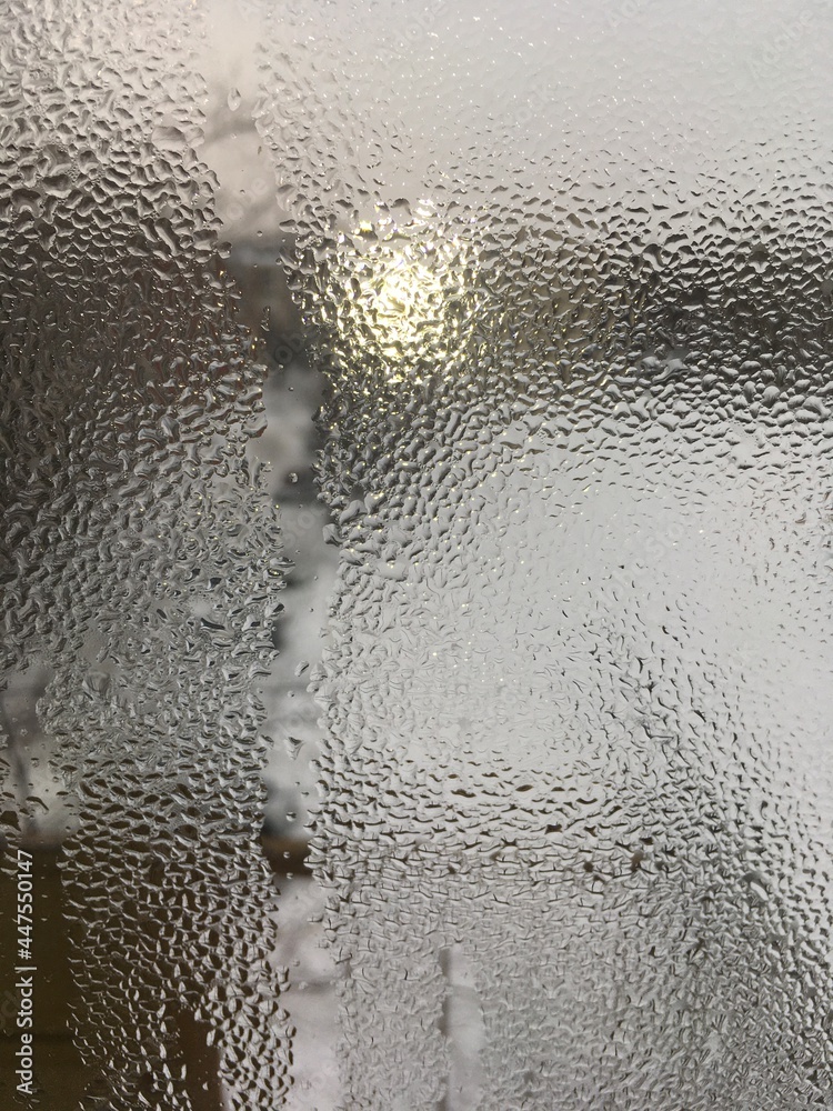 view from the window wet glass covered with wet flowing water, snow melts view from the window wet glass covered with wet flowing water, snow melts