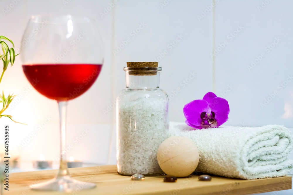 Spa-beauty salon, wellness center. Spa treatment aromatherapy for the female body in the bathroom with a glass of wine, with candles, oils and salt Spa-beauty salon, wellness center. Spa treatment aromatherapy for the female body in the bathroom with a glass of wine, with candles, oils and salt