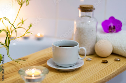 Spa-beauty salon, wellness center. Aromatherapy spa treatment for the female body in the bathroom with a cup of coffee, candles, oils and salt.