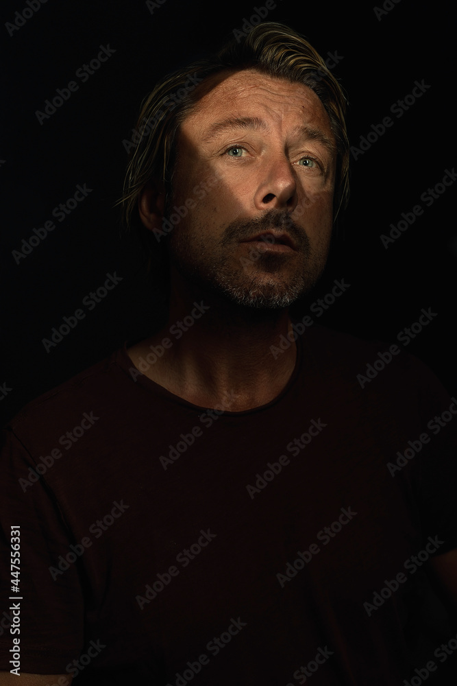 Dark mysterious portrait of a blond man with light blue eyes and Dark mysterious portrait of a blond man with light blue eyes and