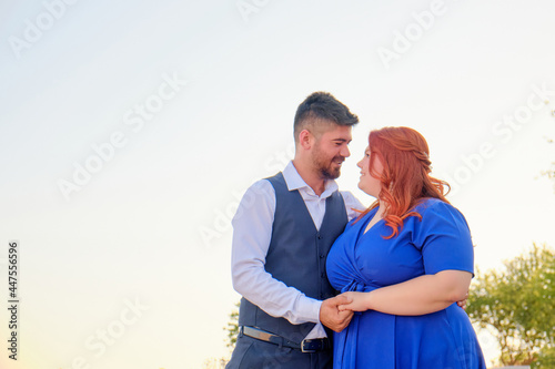 Turkish man and his beloved caucasian plus size red headed woman embracing. Romantic date of middle eastern man and caucasian woman. Copy space
