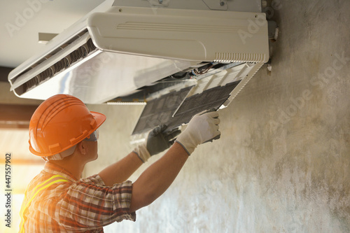 Air conditioner repairmen work on home unit photo