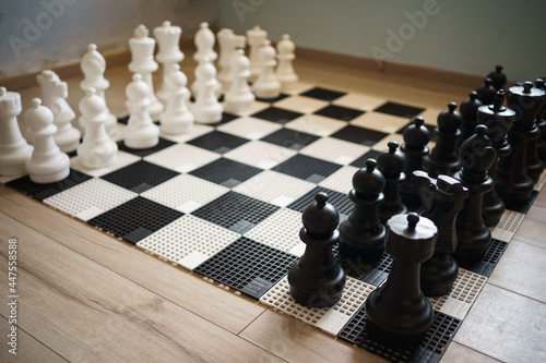 big white and black chess pieces on the floor