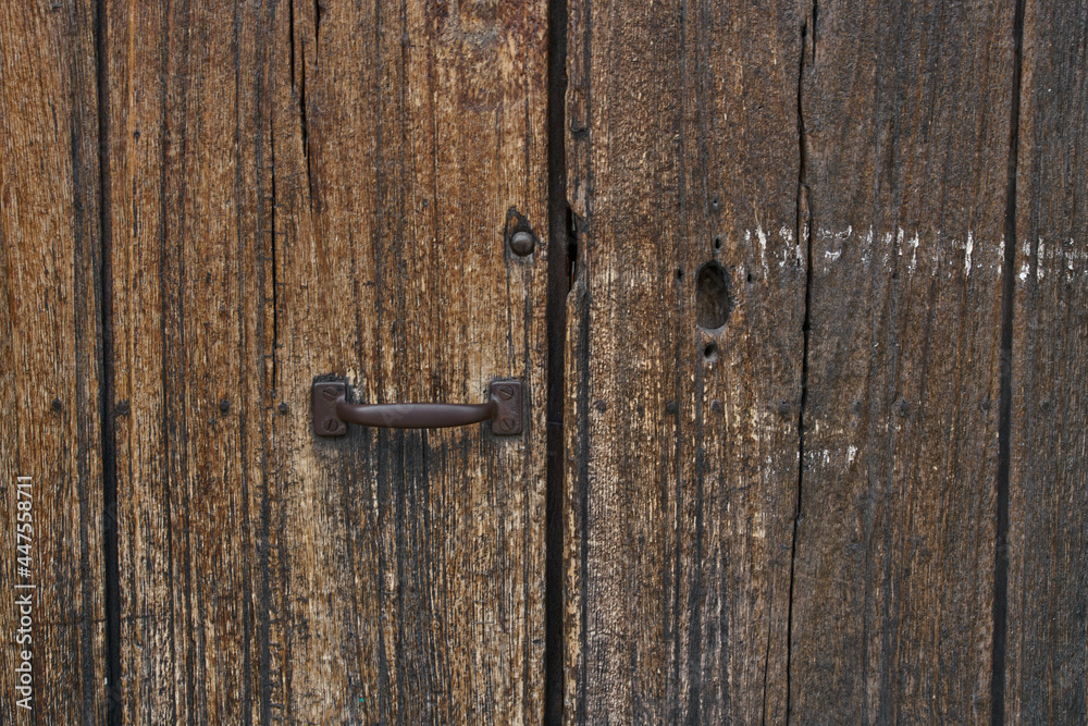 Antique wooden door with rusted hardware