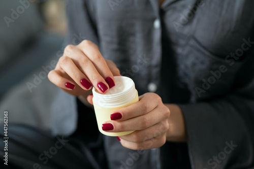 Young female applying natural handmade cosmetic product on her hands