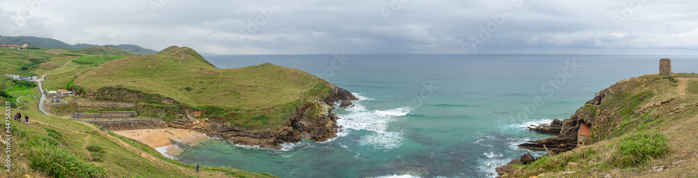 Vistas panorámicas espectaculares de la Playa de Santa Justa, con el horizonte en el mar de color azul y aguamarina y la Torre de San Telmo, en Cantabria, España, verano de 2020 Vistas panorámicas espectaculares de la Playa de Santa Justa, con el horizonte en el mar de color azul y aguamarina y la Torre de San Telmo, en Cantabria, España, verano de 2020