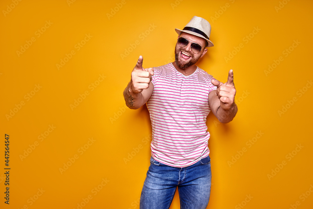 Young handsome man wearing casual t-shirt standing over isolated yellow background pointing with finger to the camera and to you, hand sign, positive and confident gesture Young handsome man wearing casual t-shirt standing over isolated yellow background pointing with finger to the camera and to you, hand sign, positive and confident gesture