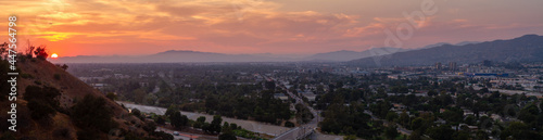 Fotografia Dramatic sunset over the city of Burbank with a plane flying over