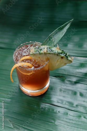 Close up of planter's punch cocktail on a banana leaf background
