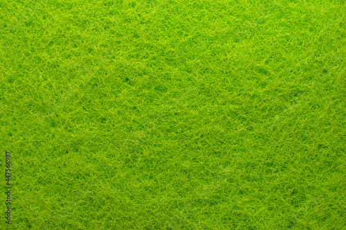 Textile. Background from green material. Enlarged spongy fibers. Sponge texture. Close up