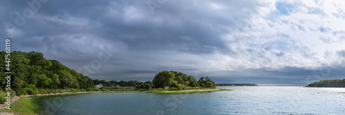 Panoramic seascape with views of islands under dramatic stormy clouds. Tranquil cove at Monk Park in Bourne  Massachusetts.