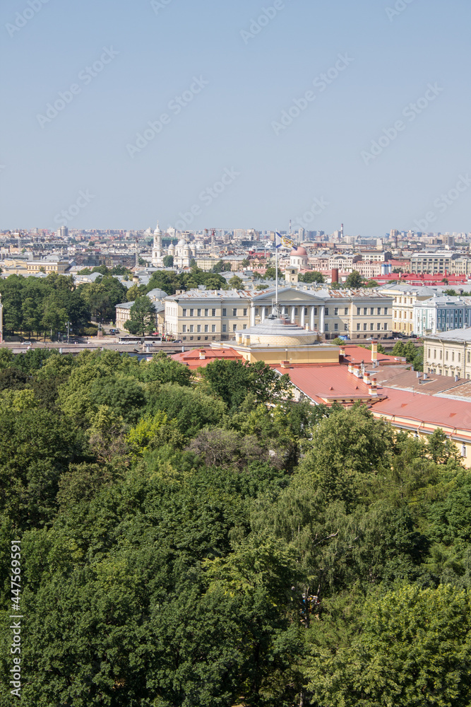 Panoramic top view of St. Petersburg Russia with the roofs of historical buildings and the green foliage of trees and a space to copy on a sunny summer day
