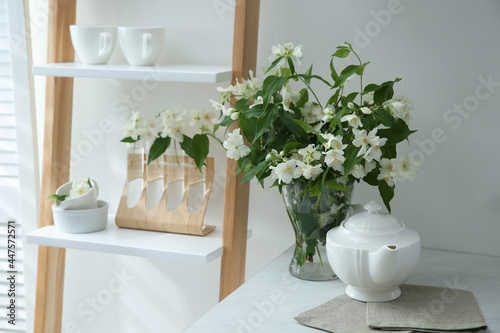Bouquet with beautiful jasmine flowers on countertop in kitchen, space for text © New Africa