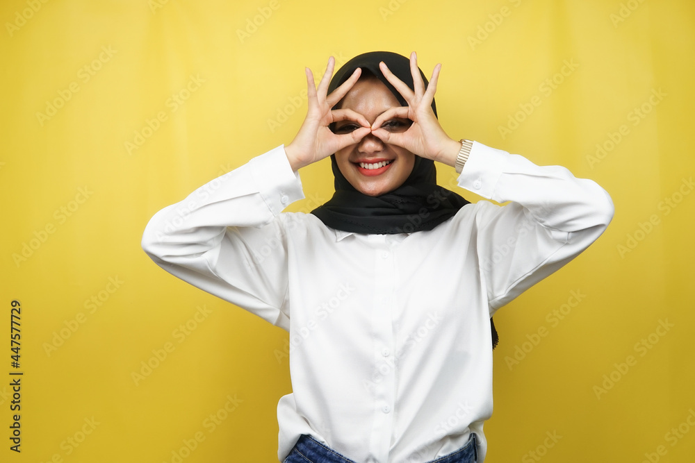 Beautiful asian young muslim woman smiling cheerfully and excitedly, with glasses hands, isolated on yellow background Beautiful asian young muslim woman smiling cheerfully and excitedly, with glasses hands, isolated on yellow background