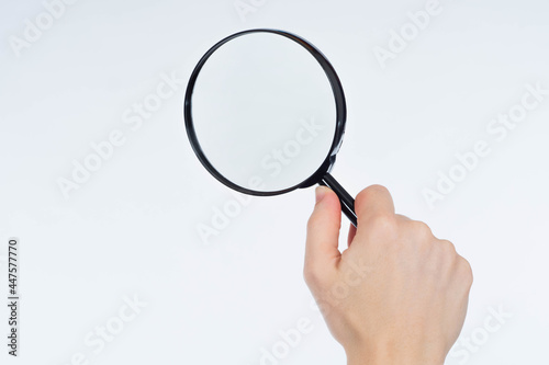 Magnifying glass. Black magnifying glass. Magnifier in hand on a white background. Loupe with copy space. Copy space with magnifying lens. Place for text near magnifier. Loupe in hand