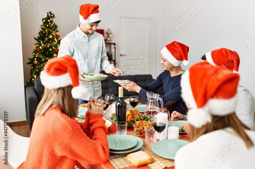 Group of young people smiling happy having christmas dinner at home.