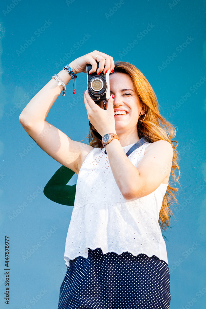 Red head young woman taking photo with retro camera Red head young woman taking photo with retro camera