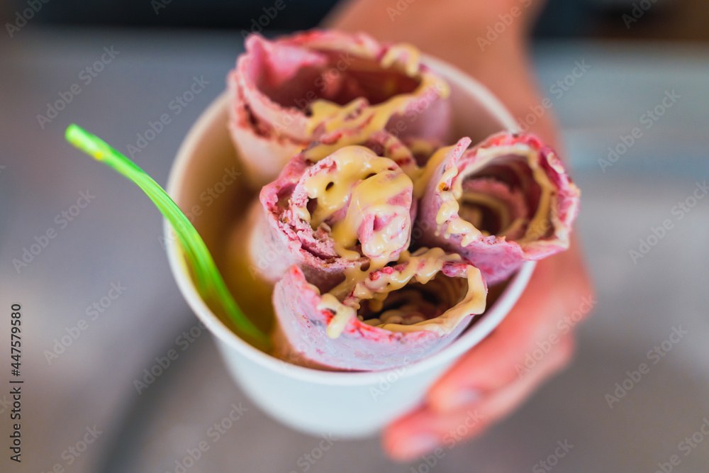 Hispanic man holding a tub of rolled ice cream in his hand. Concept of