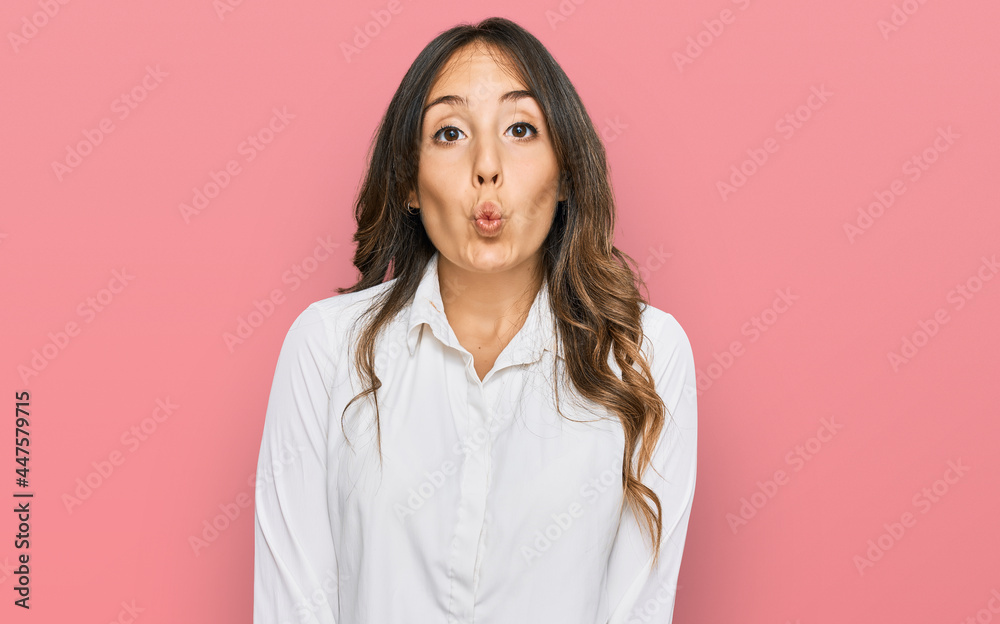 Young brunette woman wearing casual clothes making fish face with lips, crazy and comical gesture. funny expression.