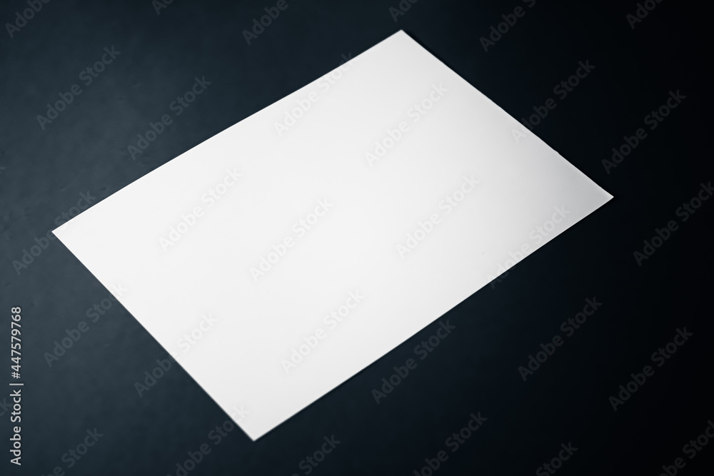 Blank A4 paper, white on black background as office stationery flatlay