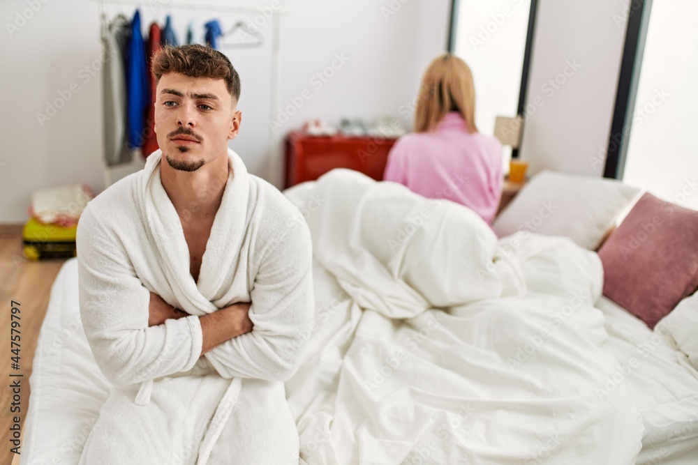 Young caucasian couple in conflict sitting on the bed at home. Young caucasian couple in conflict sitting on the bed at home.