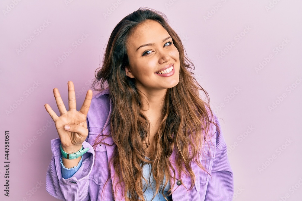 Young hispanic girl wearing casual clothes showing and pointing up with fingers number four while smiling confident and happy.