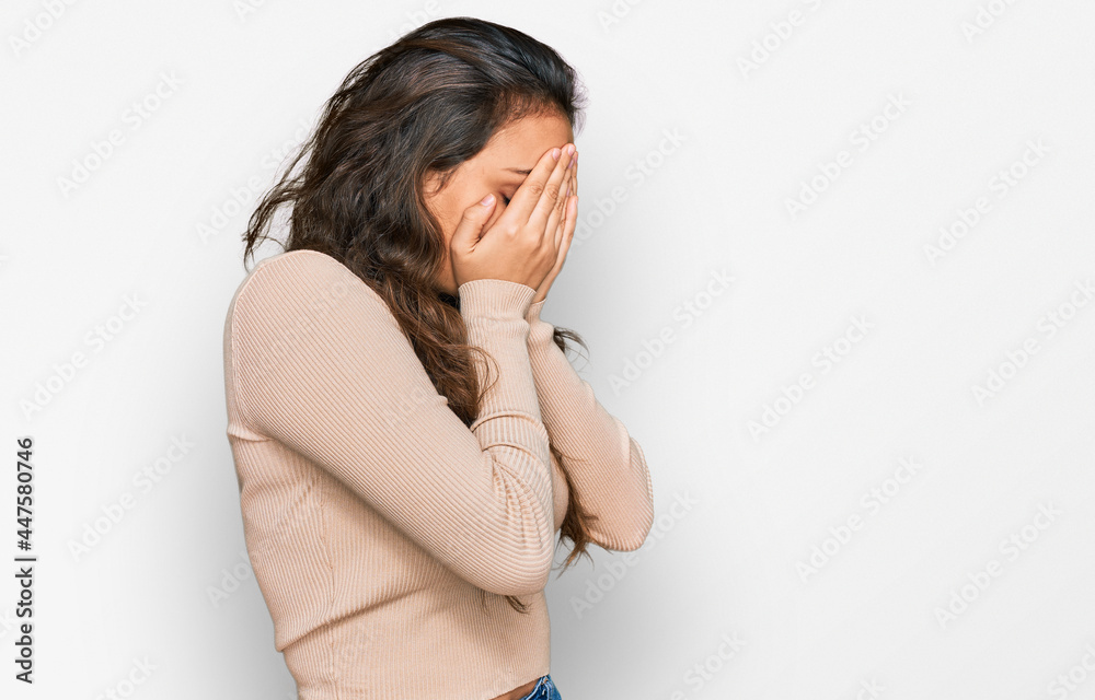 Young hispanic girl wearing casual clothes with sad expression covering face with hands while crying. depression concept. Young hispanic girl wearing casual clothes with sad expression covering face with hands while crying. depression concept.