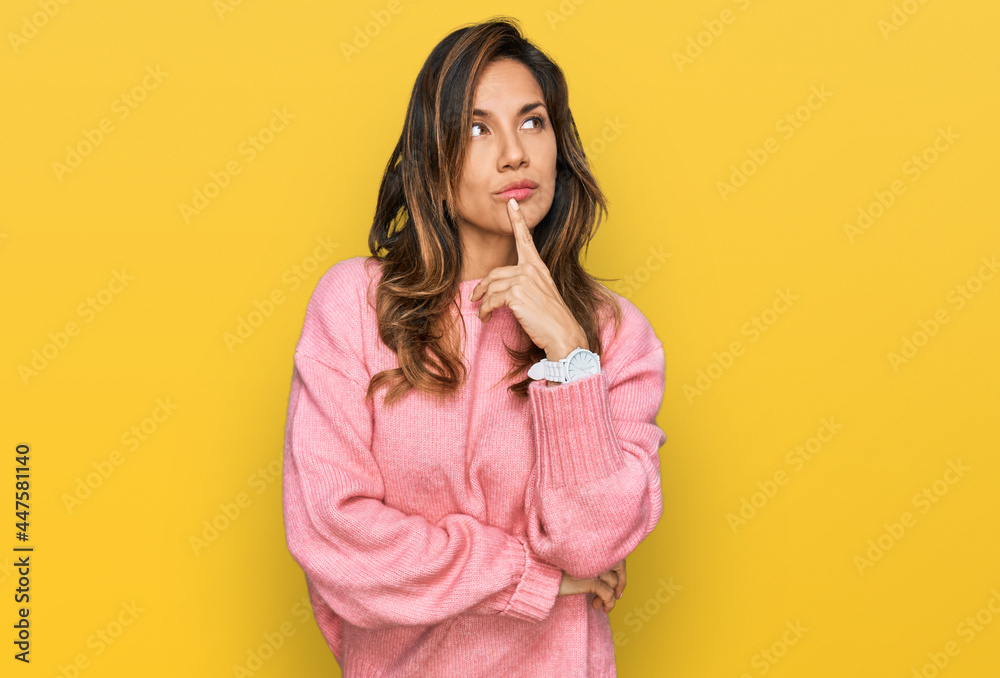 Young hispanic woman wearing casual clothes with hand on chin thinking about question, pensive expression. smiling with thoughtful face. doubt concept. Young hispanic woman wearing casual clothes with hand on chin thinking about question, pensive expression. smiling with thoughtful face. doubt concept.