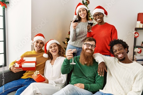 Group of young people on christmas celebration sitting on the sofa at home.