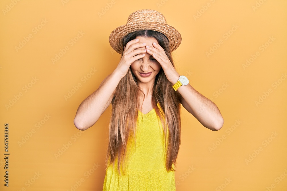 Young blonde girl wearing summer hat suffering from headache desperate and stressed because pain and migraine. hands on head. Young blonde girl wearing summer hat suffering from headache desperate and stressed because pain and migraine. hands on head.