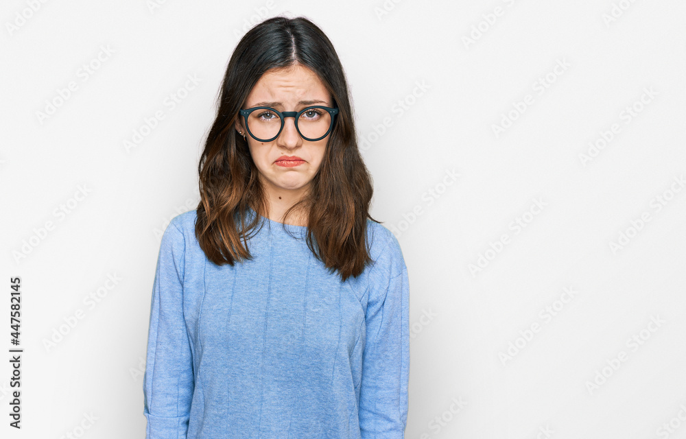 Young beautiful woman wearing casual clothes and glasses skeptic and nervous, frowning upset because of problem. negative person.