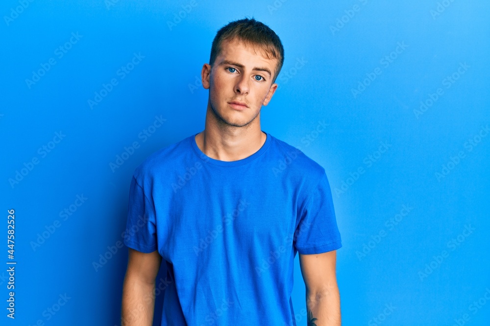 Young caucasian man wearing casual blue t shirt looking sleepy and tired, exhausted for fatigue and hangover, lazy eyes in the morning. Young caucasian man wearing casual blue t shirt looking sleepy and tired, exhausted for fatigue and hangover, lazy eyes in the morning.
